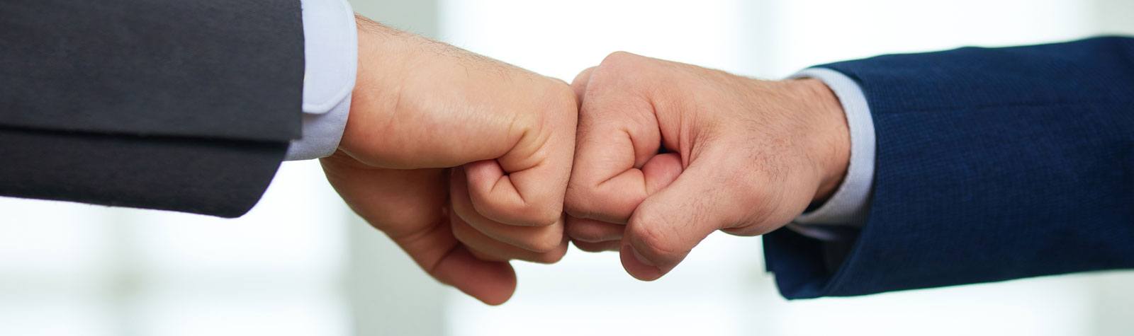 Close-up of hands fist bumping.