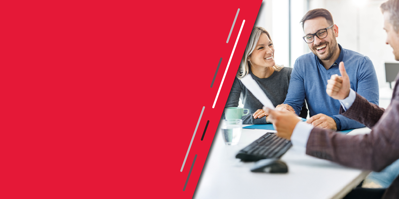 A man and women sit with a banker opening a new account